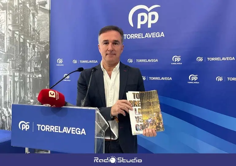 El concejal 'popular' Enrique Gómez sostiene la revista municipal de Torrelavega | Foto: Radio Studio